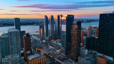 New York, ABD, 8 Ekim 2025: Doğu Nehri 'nin kıyısındaki yüksek binalara yaklaşıyoruz. Günbatımında New York 'un geniş şehir manzarası havadan izleniyor..