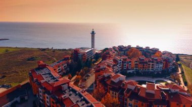 Marina Cape kompleksinde çok güzel deniz fenerleri olan göz kamaştırıcı binalar. Batan güneş tarafından göz kamaştıran geniş Karadeniz suları. Hava görünümü.