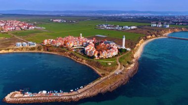 Bulgaristan 'ın Aheloy kentindeki güzel, parlak Marina Cape kompleksinden uzakta. Mavi sulardaki taş barajın orada tekneler duruyor..