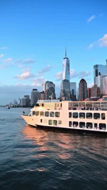 Üç güverteli modern yolcu teknesi nehir manzarası boyunca yavaş gider. Manhattan 'ın görkemli gökdelenleri. Dikey video.