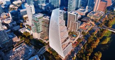 Colorado Nehri 'nin yeşil rıhtımındaki muhteşem, sıra dışı yüksek binalar. Parlak güneş Austin, Teksas 'ın manzarasını aydınlatıyor..