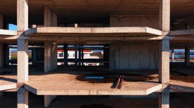 İnşaat halindeki çok katlı binanın boş katları. Binanın tepesine yükselmek yeşil alanlar ve şehir manzarasını gözler önüne seriyor.