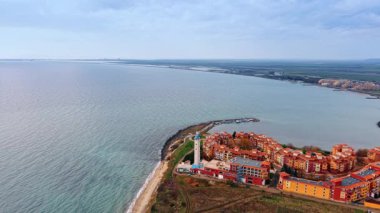 Bulgaristan 'ın Aheloy kentinde deniz feneri bulunan renkli Marina Cape kompleksi. Karadeniz 'in manzarası bulutlu gökyüzü ile birleşiyor. Hava görünümü.