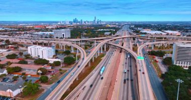 Austin, ABD, 24 Kasım 2025: Modern şehirde çarpıcı yol altyapısı. Otobanlardan çok sayıda araba geçiyor ve yeşil şehir manzarasında yürüyorlar. Hava görünümü.