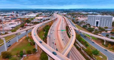 Austin, ABD, 24 Kasım 2025: Birçok araba şehir manzarasını geçen trestles ve otoyollardan geçiyor. Gündüz vakti şehirde gezip tozmak. Hava görünümü.