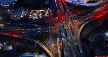 Çarpıcı büyüklükteki kavşağın yanından çok sayıda araç geçiyor. Metropolis 'teki hareketli trafiğin gece görüşü. Hava perspektifi.