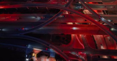 Kırmızı sokak ışıklarıyla aydınlatılmış, hareketli yollar ve tırabzanlar boyunca giden arabaları takip ediyorum. Şehirde gece seyahati. Hava görünümü.