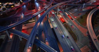 Trafiğin yoğun olduğu çarpıcı bir kavşak. Arabalar geceleri otobanlardan ve trestlerden geçer. Hava görünümü.