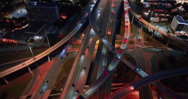 Modern şehirde sayısız arabası olan yol ve trabzanlar. Gece trafiği hareketli. Hava görünümü.