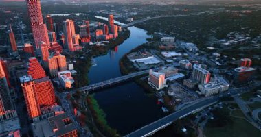Dalgalı Colorado Nehri, Austin, Teksas, ABD şehir manzarası boyunca akar. Şehir merkezindeki gökdelenler gün batımının altın ışığıyla aydınlanır. Hava perspektifi.