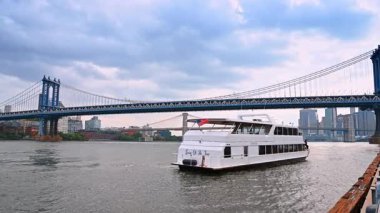 New York, ABD, 1 Ağustos 2025, Doğu Nehri 'nin kıyısındaki beyaz yolcu gemisi. Manhattan Köprüsü ve Brooklyn Köprüsü. New York, ABD 'de bulutlu bir gün.