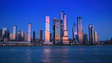 New York, ABD, 1 Ağustos 2025: Günbatımı ışığında New York binaları. Gün batımında nehir manzarasından şehrin ufuk çizgisine bak.