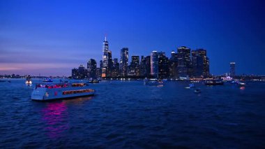 New York, ABD, 1 Ağustos 2025: Doğu Nehri 'nin koyu mavi sularında sayısız çeşitli tekne. Güzel Manhattan gökdeleninde akşam.