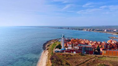 Deniz kıyısında bitişik deniz feneri olan rahat renkli bir yerleşim yeri. Bulgaristan 'ın Aheloy kentindeki Karadeniz ve Marina Cape kompleksinin güneşli sahillerine hava perspektifi.