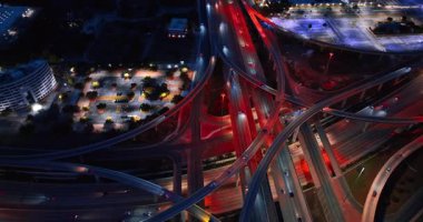 Büyük bir şehirde yoğun bir kavşak. Ulaşım otobanlardan geçiyor ve farları açık olarak tırabzanlar var. Hava görünümü.