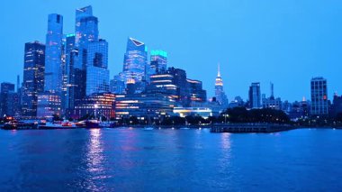New York, ABD, 22 Ekim 2025: Manhattan, New York 'un görkemli gökdeleni alacakaranlıkta. Bazı çeşitli tekneler rıhtımın yanında duruyor. Nehir manzarasından görüntüle.