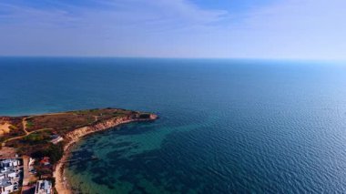Sonsuz güzellikteki mavi deniz manzarasını keserek karaya yaklaşıyoruz. Sahilde bazı evler vardır..