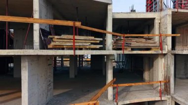 İnşaat halindeki yapının zemininde tahta yığınları var. Gelecekteki bina boyunca İHA görüntüleri.