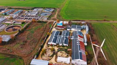 Tepesinde güneş panelleri olan uzun depoların görüntüleri. Atık su arıtma ve geri dönüşüm tesisine yaklaşıyoruz..