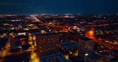 Houston, Teksas, ABD 'nin gece panoramasında manzara. Canlı trafiği olan otoyollar ışıltılı şehir manzarasını geçer. Hava perspektifi.