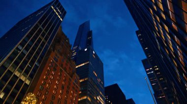 Geceleri New York 'un gökdelenleri düşük açılı perspektiften. Altın toplar ve ışıklarla süslenmiş Noel ağacına bak.
