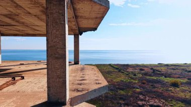 Güzel deniz manzarasının kıyısındaki terk edilmiş bina turu. Bitmemiş inşaatın zemininde büyük bir su birikintisi ve biraz enkaz var..