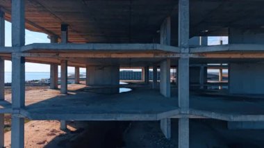 Terk edilmiş binanın zemininde uçuyor. Arkaplanda güzel deniz manzarasında bazı binalar.