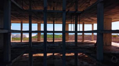 Çok katlı yapının içindeki boşluğun içine giriyoruz. Mavi deniz manzarası boş binanın zemininde olabilir..