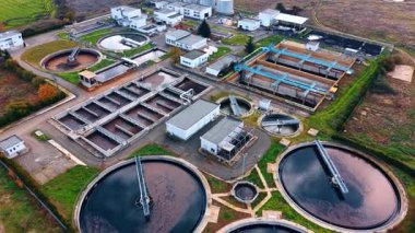 Modern atık su arıtma tesisinden uzağa uçuyorlar. Büyük yuvarlak havzalar kanalizasyonla dolu..