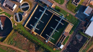 Atık su arıtma tesisi üzerinde uçuş. Yolda yürüyen insan, büyük kanalizasyon rezervuarı boyunca yürür..