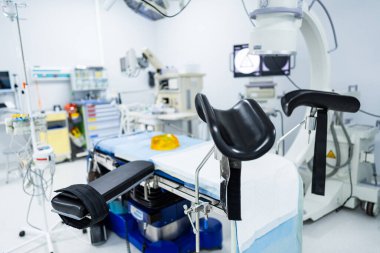 Modern Ameliyathanede Stirrups ile Cerrahi Masa. Steril bir hastane odasında jinekolojik ya da ürolojik işlemler için bacak üzengisiyle donatılmış bir ameliyat masasının ayrıntılı görüntüsü.