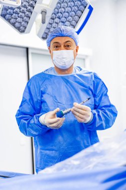 Cerrah ameliyathanede cerrahi alet tutuyor. Etkin kullanım için tıbbi profesyonel hazırlık aygıtı