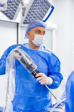 Cerrahın elinde cerrahi alet var. Kontrollü operasyon için tıbbi cihaz hazırlanıyor