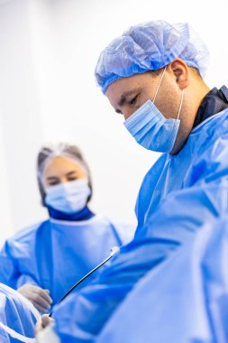 Cerrahi personel birlikte işlem yapıyor. Koordineli operasyonel iş akışında çalışan tıp uzmanları