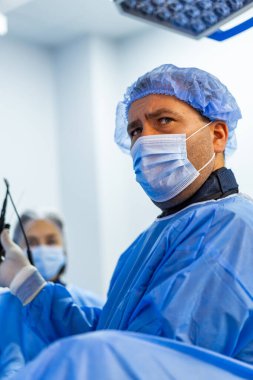 Cerrah cerrahi aletini ameliyat halinde tutuyor. Steril işlem sırasında klinik profesyonel hazırlık aygıtı