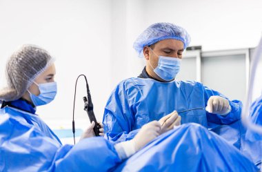 Ameliyat sırasında enstrüman kullanan cerrahi ekip. Koordineli tıbbi personel tarafından gerçekleştirilen klinik operasyon