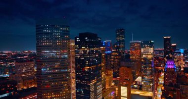Houston, Teksas 'ın yüksek binaları ve gökdelenleri kara bulutlu gökyüzüne karşı. Gece vakti metropolün merkezine iniyor..