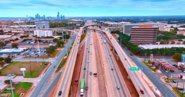 Çok şeritli yollarda arabalarla uçmak. Yukarıdaki köprüyle kavşağa yaklaşıyoruz. Arkaplanda büyük bir şehrin silüeti.