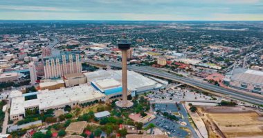 Amerika Kulesi 'nin etrafında uçuyor. San Antonio, Teksas, ABD şehir manzarası üzerinden geçen hareketli otoyola bakın. Bulutlu bir günde İHA görüntüleri.