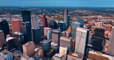 Houston, Teksas, ABD şehir merkezindeki çeşitli yüksek binaların üzerinden uçuş. Şehir merkezini ayıran hareketli kavşağa ve yollara yaklaşıyoruz..