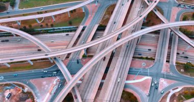 Yollarda ve trabzanlardaki arabaları süratle hareket ettirin. Büyük bir şehirdeki çok şeritli kavşakta trafik vardı. Hava görünümü.