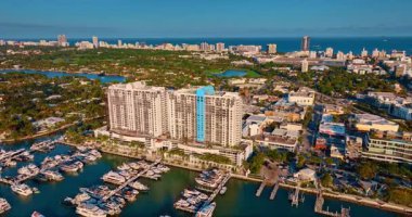 Mesafe, suyun üzerine inşa edilmiş çok katlı benzer çok katlı binaları oluşturur. Binaların önünde sayısız modern tekne ve yatları olan rıhtımlar. Miami, Florida, ABD.