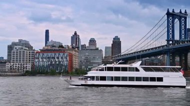 New York, ABD, 12 Ağustos 2025, feribot Manhattan Köprüsü 'ne yanaşıyor. Manhattan Köprüsü ve şehrin silueti yakınlarındaki East River 'da yolcu feribotu kalkıyor..