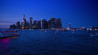 Doğu Nehri 'nin karanlık sularında sayısız gemi var. Manhattan, New York, ABD 'nin gece ufuk çizgisinde alçak açı görüntüsü.