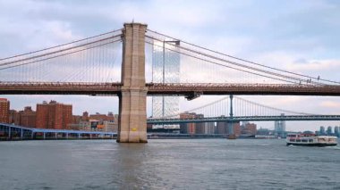New York, ABD, 12 Aralık 2025, Brooklyn Köprüsü ile Manhattan Köprüsü arasındaki su manzarası boyunca seyir gemisi hareket ediyor. Arka planda New York silueti.