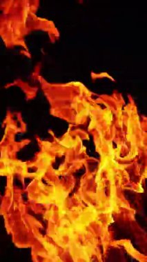 Karanlıkta hareket eden güzel ateş alevleri. Birden fazla kıvılcım yükselir ve duman arkadan yükselir. Kapatın. Dikey video