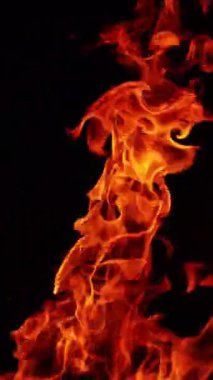 Havada yükselen kamp ateşi manzarası var. Güzel alevler geceleri yanıyor. Kapatın. Dikey video