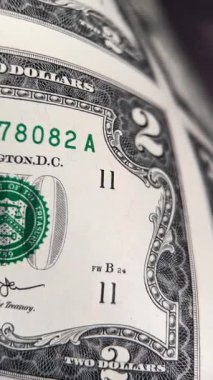 Kesilmemiş büyük bir kağıda basılmış iki dolarlık banknotlara çok yakından bakın. Amerikan para konsepti. Dikey video.