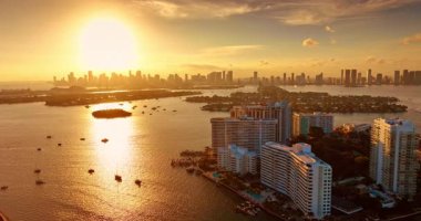 Altın günbatımı Biscayne Körfezi 'ni birden fazla gemiyle aydınlatıyor. Arka planda Miami 'deki gökdelenlerin siluetlerine bak. Hava görünümü.