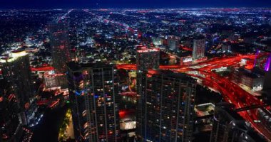 Gece Miami 'de üst geçitler var. Kırmızı ışık ve hareketli trafik ile devasa yol kavşağına yaklaşıyoruz..